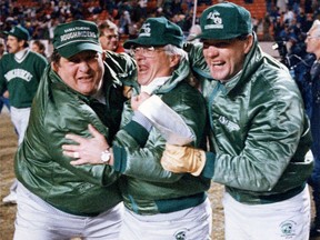 Saskatchewan Roughriders coaches Ted Heath, left to right, John Gregory and Ron Cherkus get into the winning spirit as they march across the field after defeating the Edmonton Eskimos for the Western Final in Edmonton on Sunday, November 19, 1989. Former CFL coach John Gregory, who guided the Saskatchewan Roughriders to a Grey Cup victory in 1989, has died. He was 84.