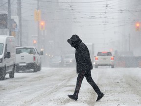 A man runs across a downtown street during a winter storm in Toronto on Wednesday, Feb. 27, 2019.