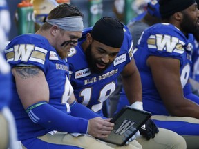 Winnipeg Blue Bombers linebackers Adam Bighill (4) and Kyrie Wilson (19) look at film during the first half of CFL action against the Edmonton Eskimos in Winnipeg Friday, May 31, 2019. The Winnipeg Blue Bombers have signed Wilson to a one-year contract extension.