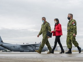 8 Wing Commander Col. Ryan Deming walks on the tarmac alongside the Minister of National Defence of Canada Anita Anand and Chief Warrant Officer Dan Baulne after announcing the transport of up to 150 Armed Forces members into Poland to assist with Ukrainian refugee resettlement efforts in Trenton, Ontario.