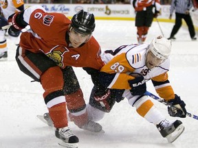 New York Islanders' Mike Comrie and Ottawa Senators' Wade Redden get dangled up during first period NHL hockey action in Ottawa, Thursday, Dec. 27, 2007. Redden was a mainstay on the Ottawa Senators blue-line for 11 years and for his efforts the fan favourite is the first player to be inducted into the team's Ring of Honour.