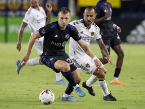 CF Montreal defender Alistair Johnston, left, takes the ball away from LA Galaxy midfielder Victor Vazquez during the second half of an MLS soccer match in Carson, Calif., Monday, July 4, 2022.
