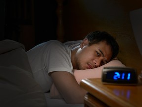 Depressed man suffering from insomnia lying in bed. Getty Images/iStockphoto
