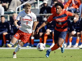 Clemson's Brandon Parrish (11) battles Syracuse's Levonte Johnson (14) for control of the ball during the first half of the Atlantic Coast Conference Men's Soccer Tournament championship match in Cary, N.C., Sunday, Nov. 13, 2022. Canadian forward Johnson, who helped Syracuse to the NCAA College Cup on Monday, is one of three finalists for the 2022 MAC Hermann Trophy.