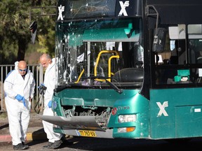 Israeli forensic experts work at the scene of an explosion at a bus stop in Jerusalem on Nov. 23.