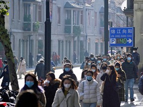 People wearing face masks walk in Shanghai, China, as COVID-19 outbreaks continue, December 13, 2022.