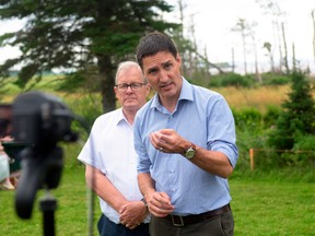 Prime Minister Justin Trudeau speaks to the media, as Veterans Affairs Minister Lawrence MacAulay looks on, in Stratford, P.E.I., on July 22.