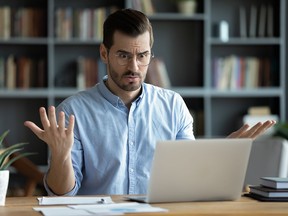 Exasperated man looks at a computer.