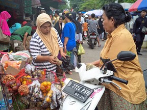 A fruit vendor prepares her customer's order at a market in Jakarta on December 2, 2022. Indonesia is the world's most populous Muslim-majority nation.