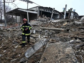 A rescuer walks amid rubbles of a destroyed building following Russian strikes in Kharkiv, eastern Ukraine on December 16, 2022.