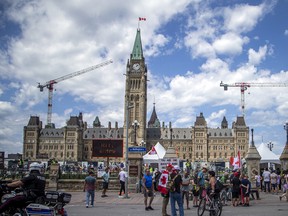 A small group protests on Wellington Street in Ottawa outside the gates of Parliament Hill, July 2, 2022. The federal government’s jurisdiction currently ends as soon as someone steps off Parliament Hill and onto Wellington Street.