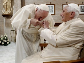 In this file photo taken on November 28, 2020 and released on February 9, 2022 by the Vatican press office shows Pope Francis (L) during a visit to Pope Benedict XVI at his residence of the Mater Ecclesiae Monastery in the Vatican.