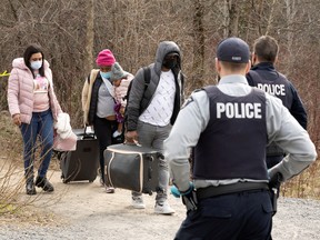 Asylum seekers cross into Canada from the U.S. border near a checkpoint on Roxham Road near Hemmingford, Quebec, April 24, 2022.