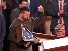 Ukraine President Volodymyr Zelenskyy holds an American flag given to him by U.S. Speaker Nancy Pelosi as he addresses a joint meeting of Congress at the U.S. Capitol on December 21, 2022.