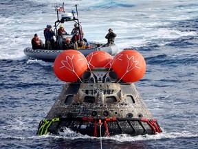 A U.S. Navy boat from the USS Portland retrieves NASA's Orion capsule after it splashed down in the Pacific off the coast of Baja California, Mexico, on Dec.11, 2022.