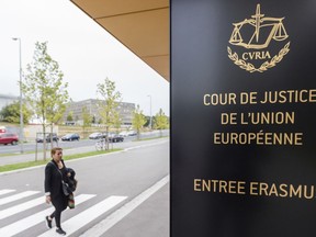 FILE - In this photo taken on Oct. 5, 2015 a woman walks by the entrance to the European Court of Justice in Luxembourg. The European Union's top court says Google has to delete search results about people in Europe if they can prove that the information is clearly wrong. People in Europe have the right to ask search engines to delete links to outdated or embarrassing information about themselves, even if it is true, under a principle known as "right to be forgotten."