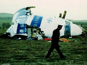 FILE - A police officer walks by the nose of Pan Am flight 103 in a field near the town of Lockerbie, Scotland where it lay after a bomb aboard exploded, killing a total of 270 people, Wednesday, Dec. 21, 1988. Authorities in Scotland on Sunday, Dec. 11, 2022 say the Libyan man suspected of making the bomb that destroyed a passenger plane over Lockerbie, Scotland, in 1988 is in U.S. custody.
