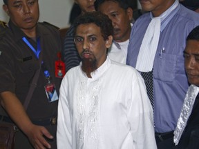 File - Indonesian Muslim militant Umar Patek is escorted by prosecutors and plain-clothed police officers as he leaves the courtroom after his hearing at West Jakarta district court in Jakarta, Indonesia, Monday, May 21, 2012. A bombmaker in the 2002 Bali attack that killed 202 people has walked free from an Indonesian prison Wednesday, Dec. 7, 2022 after serving half of a 20-year sentence, despite upsetting Australia's leader who described him as "abhorrent." Umar Patek, 55, whose real name is Hisyam bin Alizein, was a leading member of the al Qaida-linked network Jemaah Islamiyah.