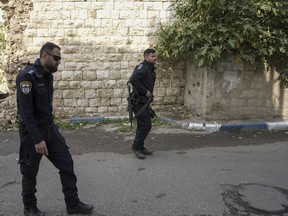 Israeli policemen walk towards the house of an Arab assailant in the Arab Israeli town of Kfar Qassem, Israel, Friday, Dec. 23, 2022. Israeli police on Friday shot dead 22-year-old Naim Badir who they said lured officers into an ambush in which he rammed them with his car after trying to shoot them, an attack that left three policemen wounded in central Israel.