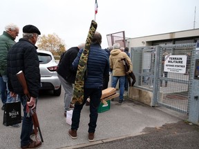 People wait to bring back their weapons to the Ustaritz gendarmerie, southwestern France, Thursday, Dec.1, 2022. France has launched a nationwide push to collect millions of old firearms; remnants of the two World Wars or long-abandoned hunting habits.
