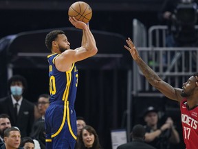 Golden State Warriors guard Stephen Curry, left, shoots a 3-point basket over Houston Rockets forward Tari Eason (17) during the first half of an NBA basketball game in San Francisco, Saturday, Dec. 3, 2022.