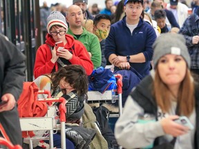 Hundreds of WestJet passengers line up as they wait to rebook cancelled flights at the Calgary International Airport on December 20, 2022. Weather issues across Canada have caused flight delays and cancellations.