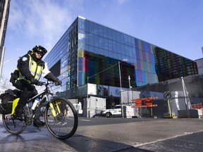 A Police officer rides his bike around the fenced off perimeter of the Convention Centre ahead of the COP15 UN conference on biodiversity in Montreal, Thursday, Dec. 1, 2022.