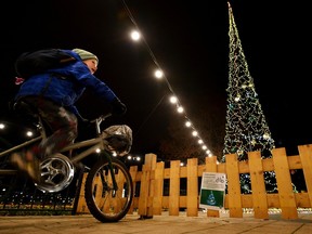 A kid rides a bicycle to power a Christmas lights installation in a Budapest district square to save costs with sustainable lights, in Budapest, Hungary, Nov. 28.