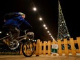 A kid rides a bicycle to power a Christmas lights installation in a Budapest district square to save costs with sustainable lights, in Budapest, Hungary, Nov. 28.