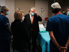 Ontario Premier Doug Ford attends a photo opportunity with healthcare workers at a medical institute before speaking at news conference in Toronto, Thursday, Dec. 1, 2022.&ampnbsp;Ontario's premier says he will not use the notwithstanding clause after a court struck down a law that limits wages for public sector workers.