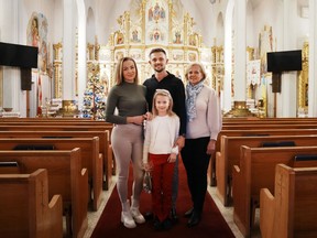 Vitali Hrechka poses for a photo with his wife Evelina, daughter Emiliia, and mother Hanna, after the St. Nicholas Day celebration at St. Demetrius Ukrainian Orthodox Church in Toronto on Sunday, Dec. 18, 2022.