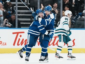Toronto Maple Leafs' Mitchell Marner (left) celebrates with Auston Matthews after scoring an empty net goal against the San Jose Sharks during third period NHL hockey action in Toronto, on November 30, 2022.