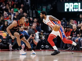 Brooklyn Nets guard Kyrie Irving (11) dribbles against Toronto Raptors forward Scottie Barnes (4) during the first half of their NBA game in Toronto on Friday, Dec. 16, 2022.