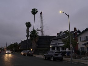 FILE - A vehicle drives past the Jefferson oil drill site located in the residential area in Los Angeles, June 2, 2021. The Los Angeles City Council voted on Friday, Dec. 2, 2022, unanimously to ban new oil and gas drill sites and phase out existing ones over the next 20 years on Friday.