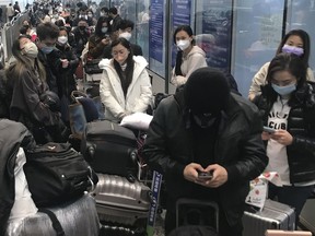 Inbound travelers waiting for hours to board buses to leave for quarantine hotels and facilities from Guangzhou Baiyun Airport in southern China's Guangdong province on Dec. 25 2022. The Canadian Press/AP