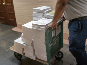Stacks of the Congressional Record are distributed as lawmakers debate a massive $1.7 trillion spending bill that finances federal agencies and provides aid to Ukraine, at the Capitol in Washington, Friday, Dec. 23, 2022.