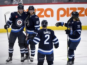 Winnipeg Jets' Kyle Connor (81) celebrates his goal against the Ottawa Senators with Pierre-Luc Dubois (80), Dylan Demelo (2) and Axel Jonsson-Fjallby (71) during second period NHL action in Winnipeg on Tuesday December 20, 2022.