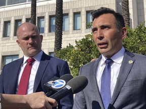 Tyler Hatcher, left, special agent in charge of Internal Revenue Service Criminal Investigation's Los Angeles field office, and U.S. Attorney Martin Estrada speak with reporters outside the federal courthouse in Santa Ana, Calif., after the sentencing of incarcerated lawyer Michael Avenatti on Monday, Dec. 5, 2022. Avenatti was sentenced to 14 years in federal prison and ordered to pay more than $10 million in restitution after admitting he cheated four of his clients out of millions of dollars.