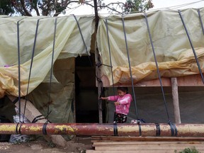 A Syrian refugee stands outside her family tent, during the visit of Canadian Minister of Immigration John McCallum to a camp in the southern town of Ghaziyeh, near the port city of Sidon, Lebanon, Friday, Dec. 18, 2015. New research indicates refugee children and youth aged under 17 do not place substantial demands on the health care system in Ontario compared with their Canadian-born peers.