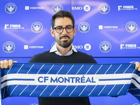 The new head coach of CF Montreal Hernan Losada holds up a CF Montreal scarf following a news conference in Montreal, Thursday, December 22, 2022. The Major League Soccer club announced Wednesday that former D.C. United head coach Hernan Losada will take over from Wilfried Nancy on the sidelines for the 2023 season.