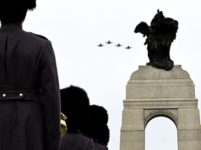 CF-18 Hornets perform a flypast at the National War Memorial during the National Remembrance Day Ceremony in Ottawa, on Friday, Nov. 11, 2022.
