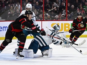 Ottawa Senators left wing Brady Tkachuk (7) tries to get his stick in front of San Jose Sharks goaltender Kaapo Kahkonen (36) as he tries to control a rebound during second period NHL hockey action in Ottawa, on Saturday, Dec. 3, 2022.