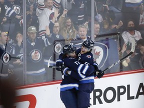 Winnipeg Jets' Adam Lowry (17) and Mark Scheifele (55) celebrates Scheifeles third goal of the game against the Vancouver Canucks during third period NHL action in Winnipeg, Thursday, December 29, 2022.