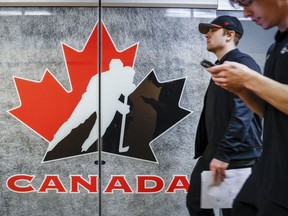 Catering staff pass by a Hockey Canada logo on the door to a meeting room at the organizations head office in Calgary, Alta., Sunday, Nov. 6, 2022.THE CANADIAN PRESS/Jeff McIntosh