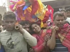 This image from video shows relatives preparing to cremate the body of a victim suspected to have died after drinking tainted liquor in Saran district of Bihar state, India, Thursday, Dec.15, 2022. More than 30 people died and more than a dozen were hospitalized in serious condition after allegedly drinking tainted liquor sold without authorization. (K K Productions via AP)