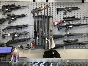 FILE - Firearms are displayed at a gun shop in Salem, Ore., on Feb. 19, 2021. An Oregon judge on Tuesday, Dec. 13, 2022, extended an earlier order blocking a key part of a new, voter-approved gun law and was hearing lengthy arguments on whether to also prevent the law's ban on high-capacity magazines from taking effect.