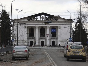 FILE - People walk past the Donetsk Academic Regional Drama Theatre in Mariupol, Ukraine, following a March 16, 2022, bombing of the theater, which was used as a shelter, in an area now controlled by Russian forces on April 4, 2022. Russian troops in Ukraine are deliberately attacking the country's museums, libraries and other cultural institutions, according to a report issued Friday Dec. 2, 2022 by the U.S. and Ukrainian chapters of the international writers' organization PEN.