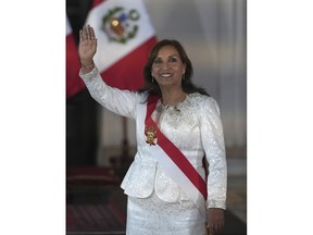 Peru's President Dina Boluarte waves as she arrives to swear in her cabinet members at the government palace in Lima, Peru, Saturday, Dec. 10, 2022.