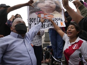 Supporters of ousted President Pedro Castillo point to a poster with a an image of newly-named President Dina Boluarte during a protest march near Congress, in Lima, Peru, Friday, Dec. 9, 2022. Peru's Congress voted to remove President Pedro Castillo from office Wednesday and replace him with the Vice President Boluarte, shortly after Castillo tried to dissolve the legislature ahead of a scheduled vote to remove him.