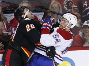 Calgary Flames' Blake Coleman, left, is checked by Montreal Canadiens' Jordan Harris during second period NHL hockey action in Calgary, Thursday, Dec. 1, 2022.
